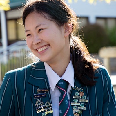 A girl in school uniform with a bright simle